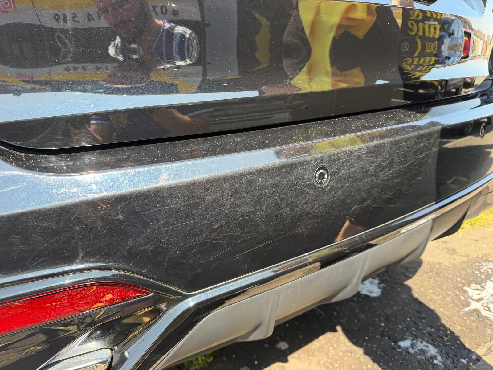 Before: black rear bumper hazed with swirl marks