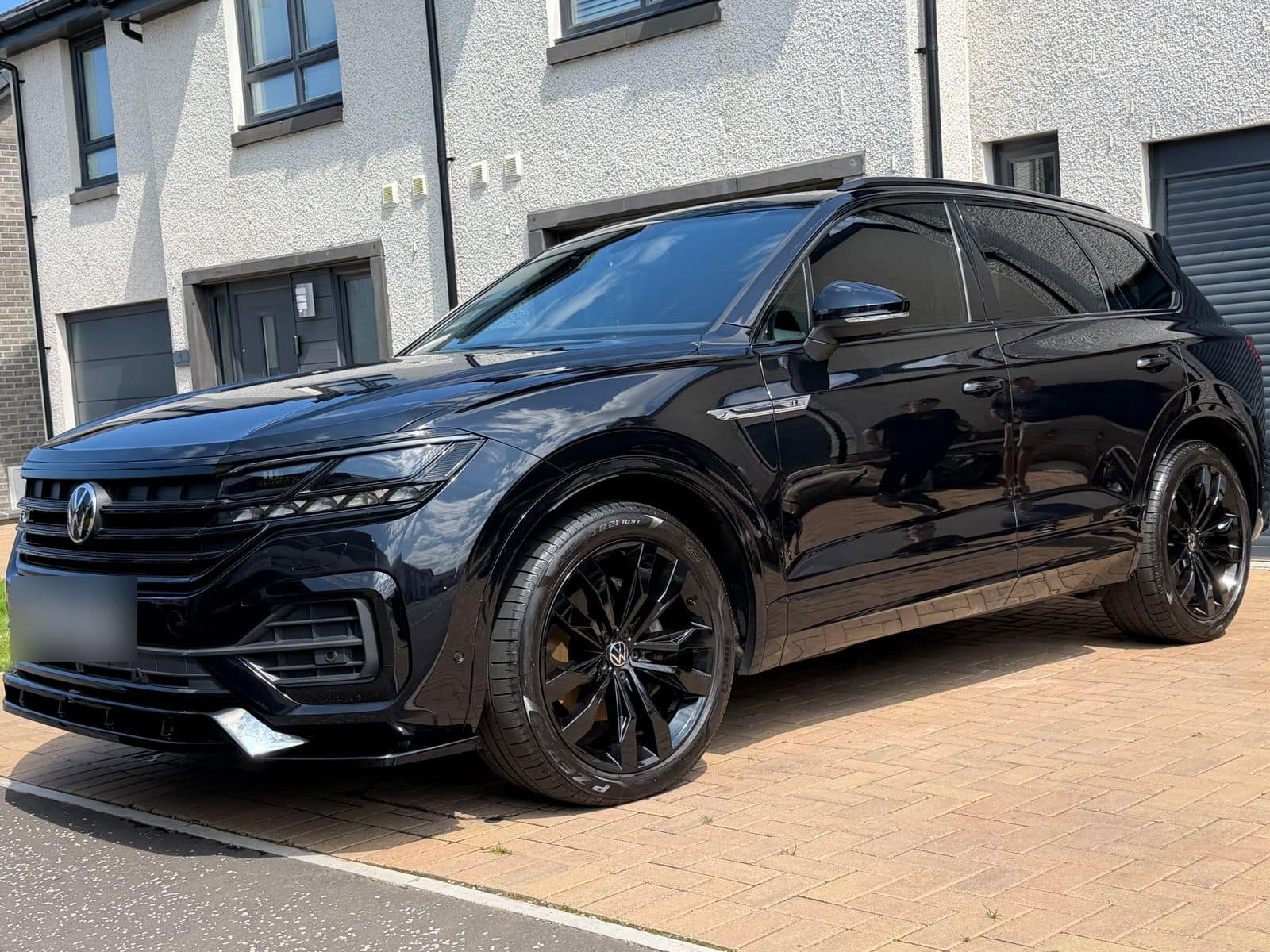 After: the same Touareg clean, with deep black paint and wheels