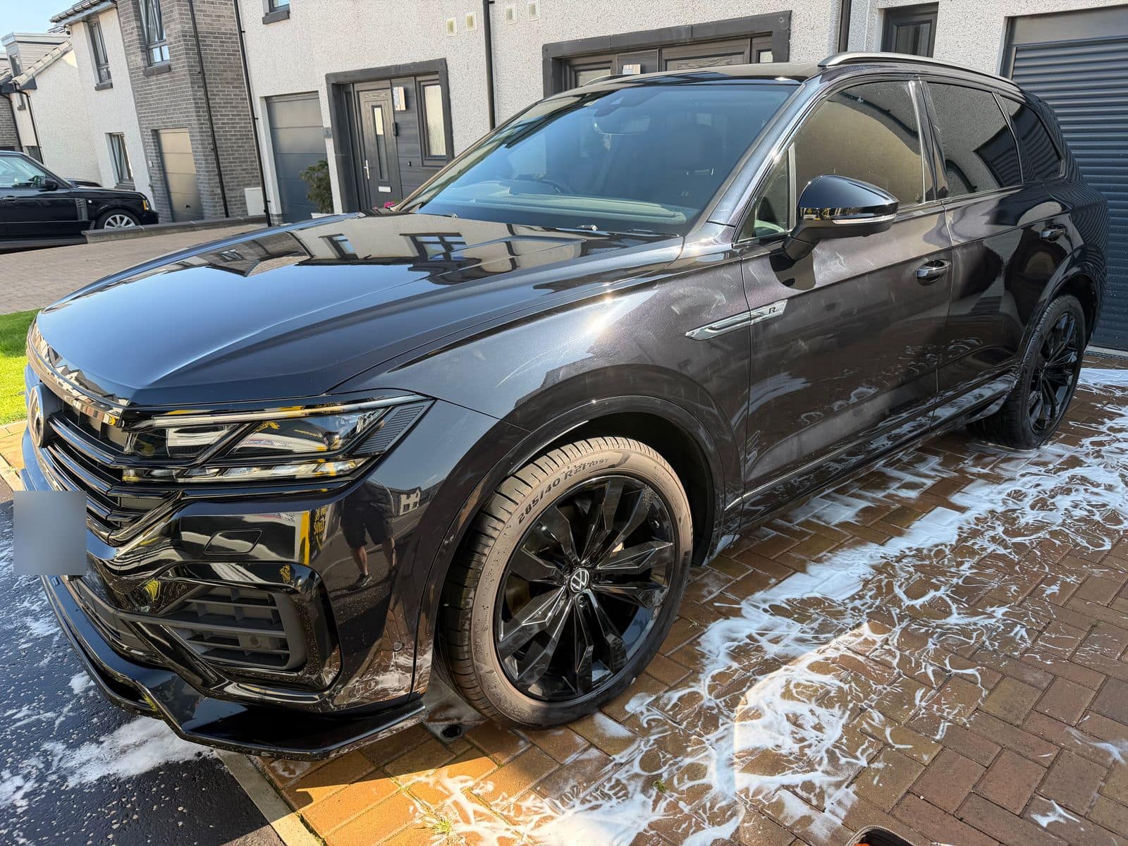 Before: black Touareg mid-wash, with dulled paint and dusty wheels