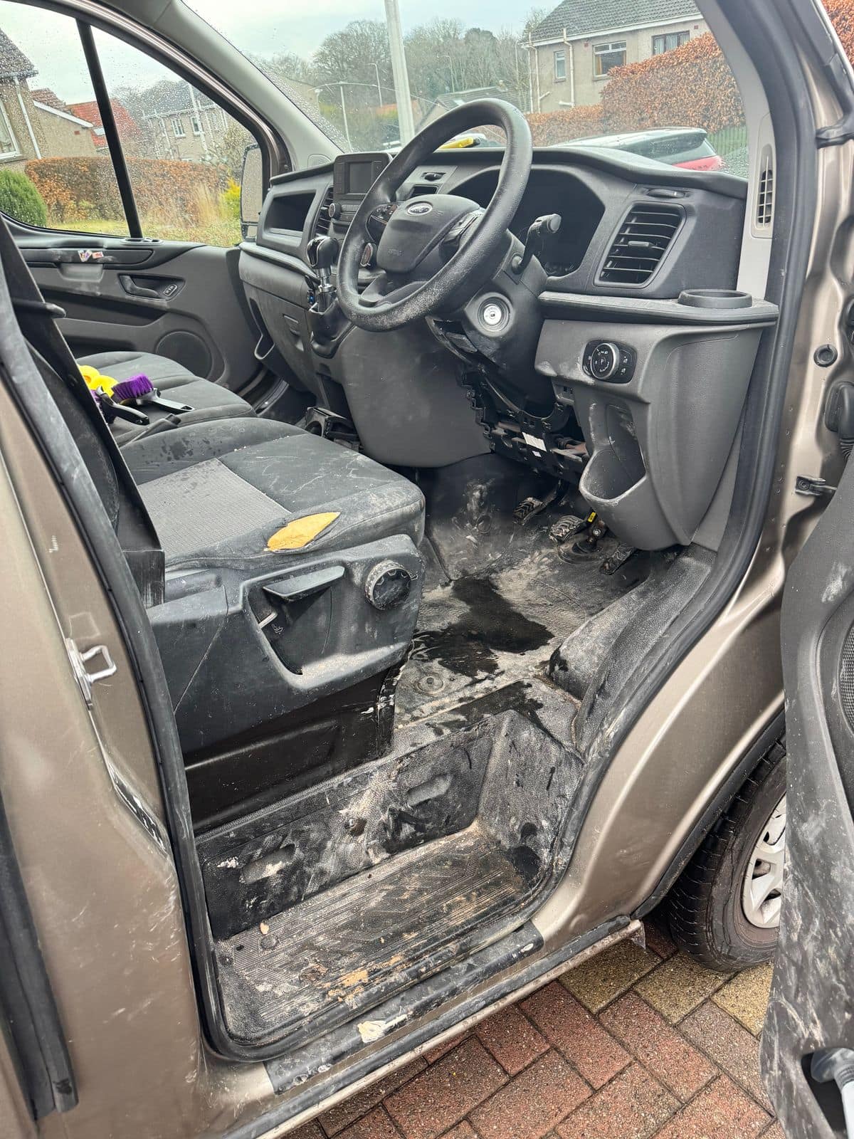 Before: van cab with dried mud across the floor and seats